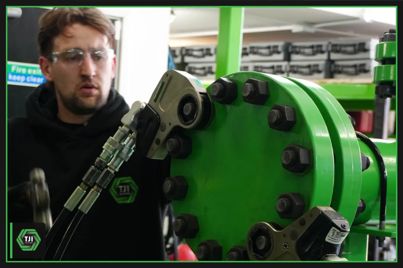 Technician using hydraulic torque wrenches on a bolted flange.